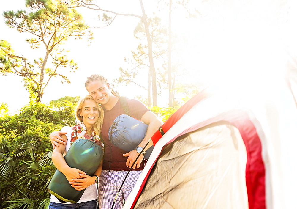 Portrait of smiling couple standing together next to tent, Tequesta, Florida