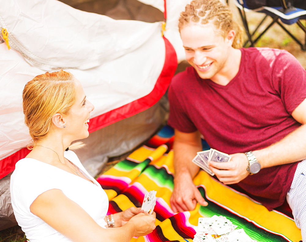 Couple playing cards in front of tent