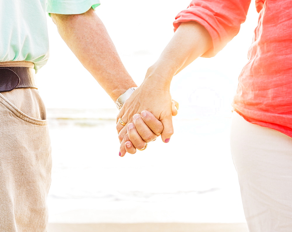 Couple holding hands on beach, Jupiter, Florida