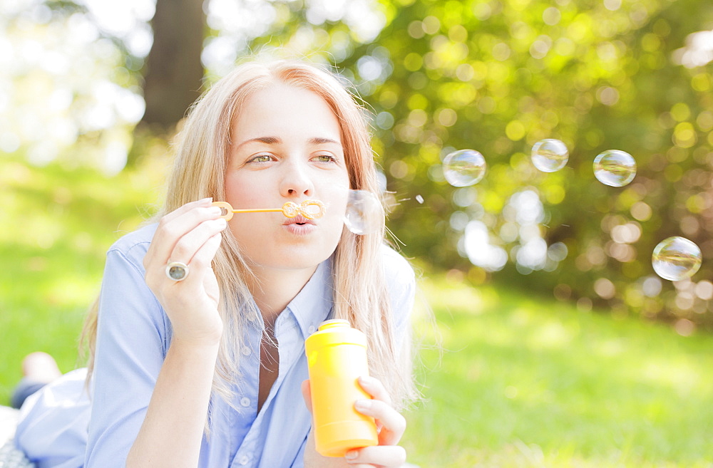 USA, New York, New York City, Manhattan, Central Park, Woman blowing bubbles