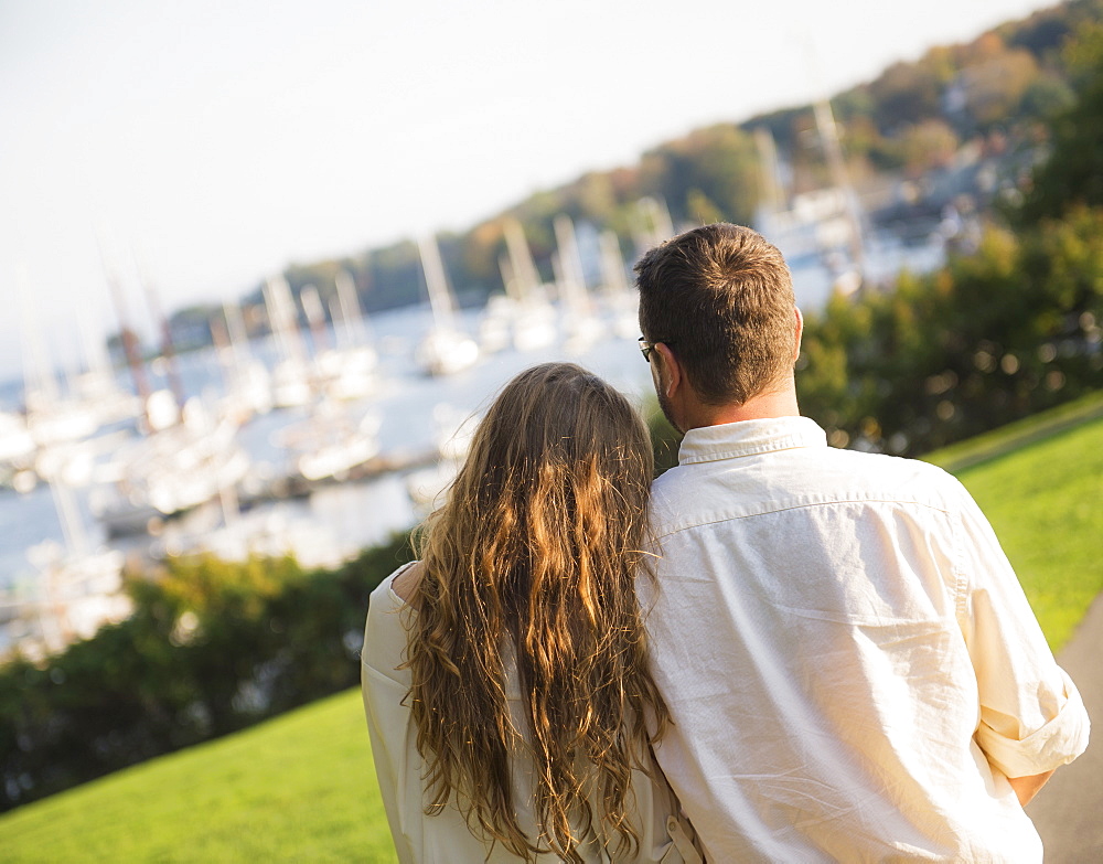 Couple walking with harbor in background, Camden, Maine