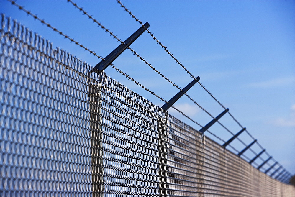 Metal fence with barbed wire