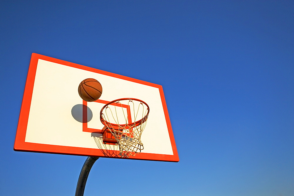 Basketball in mid air over hoop