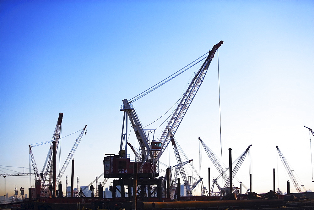 Cranes on dock at sunset