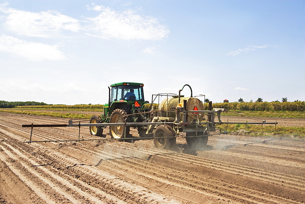 Tractor spraying field, Florida, United States