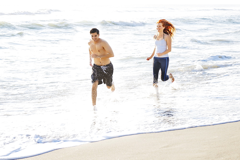 Couple running on beach, Palm Beach, Florida