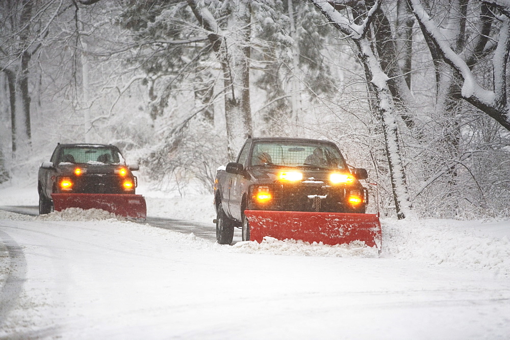 Trucks plowing snow off the road