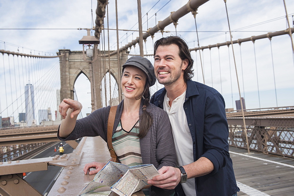 Happy couple with map on Brooklyn Bridge, Brooklyn, New York