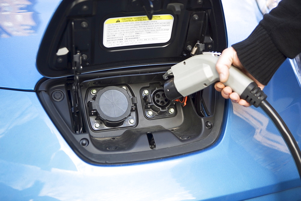 Close-up of man charging electric car