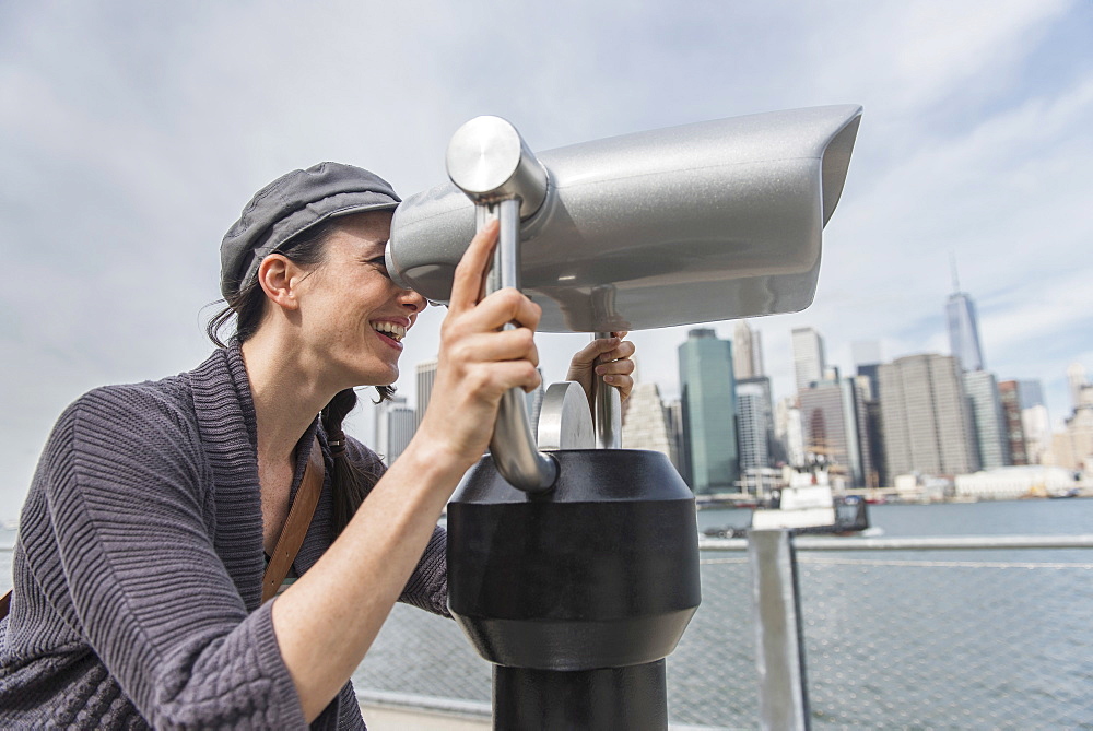 Woman watching through coin-operated binoculars, Brooklyn, New York