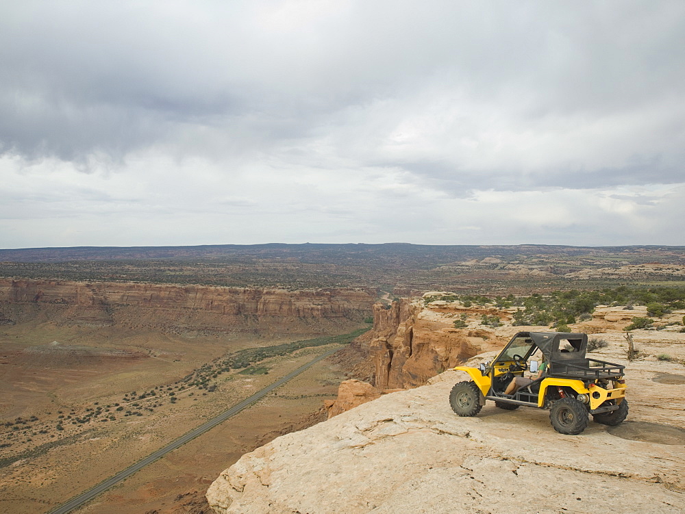 People in off-road vehicle at edge of cliff