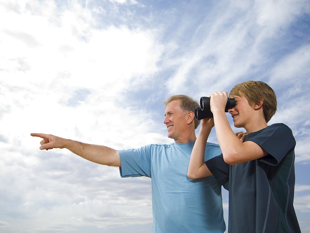 Father and son using binoculars