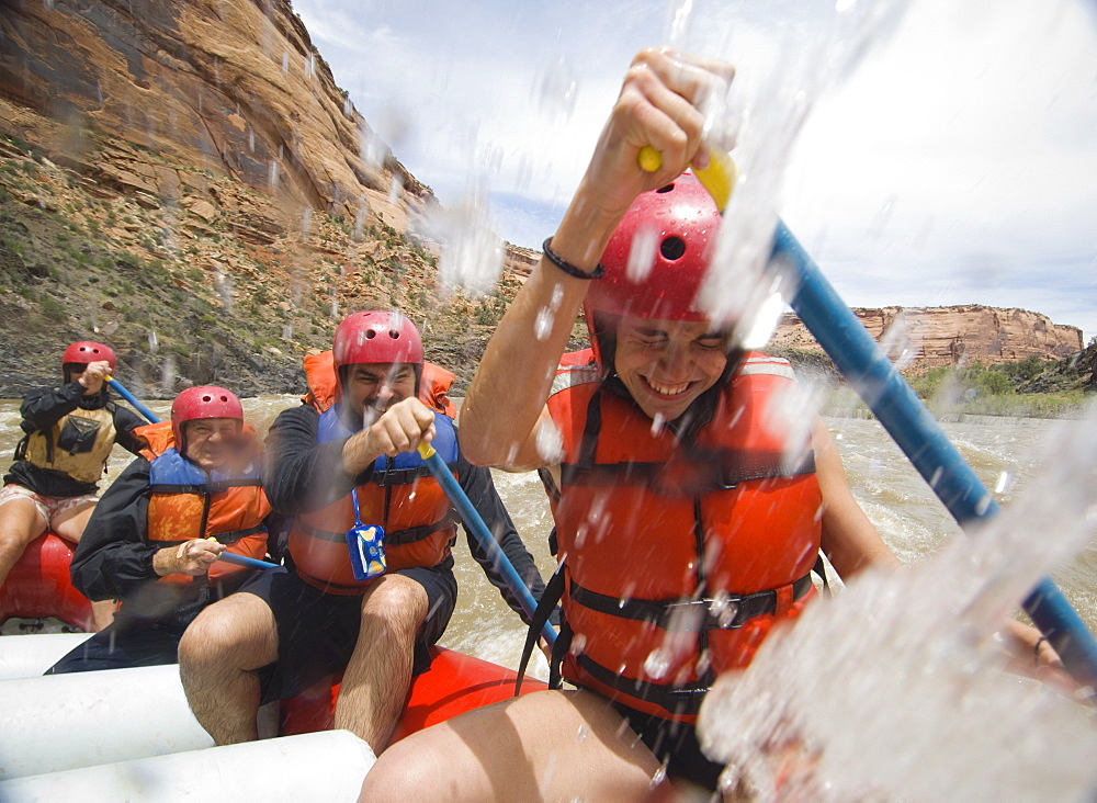 Group of people paddling in raft