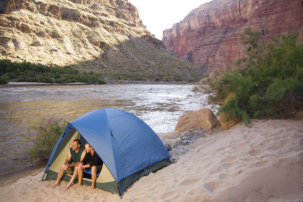 Couple in tent next to river, Colorado River, Moab, Utah, United States