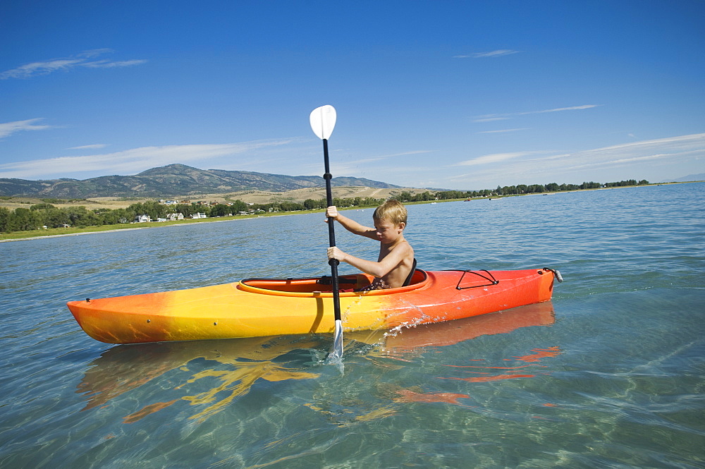 Boy paddling in canoe on lake, Utah, United States