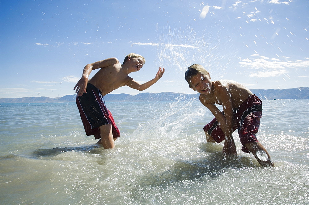 Brothers splashing in lake, Utah, United States