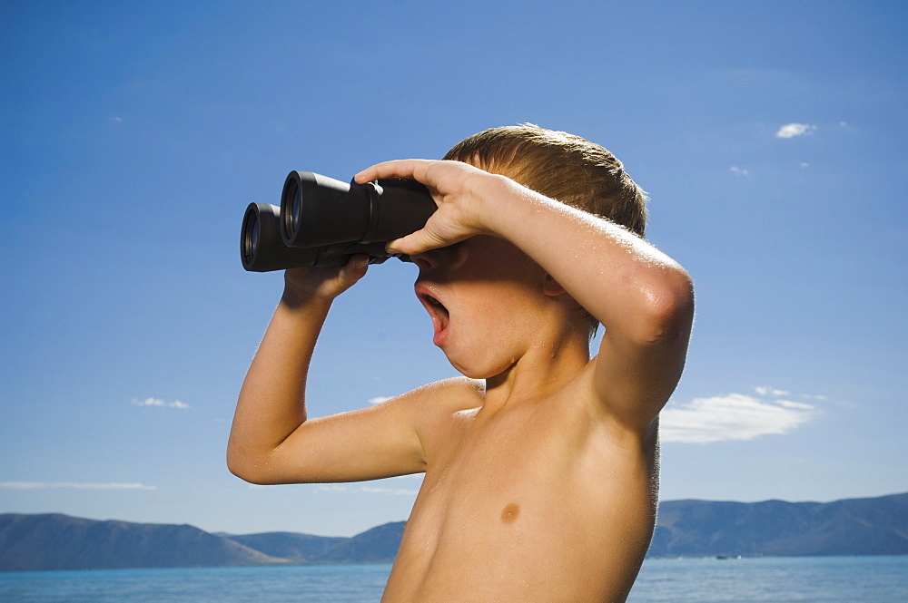 Boy looking through binoculars, Utah, United States