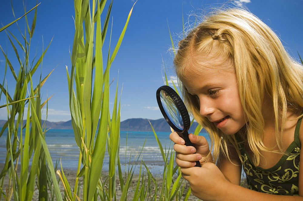 Girl looking through magnifying glass, Utah, United States