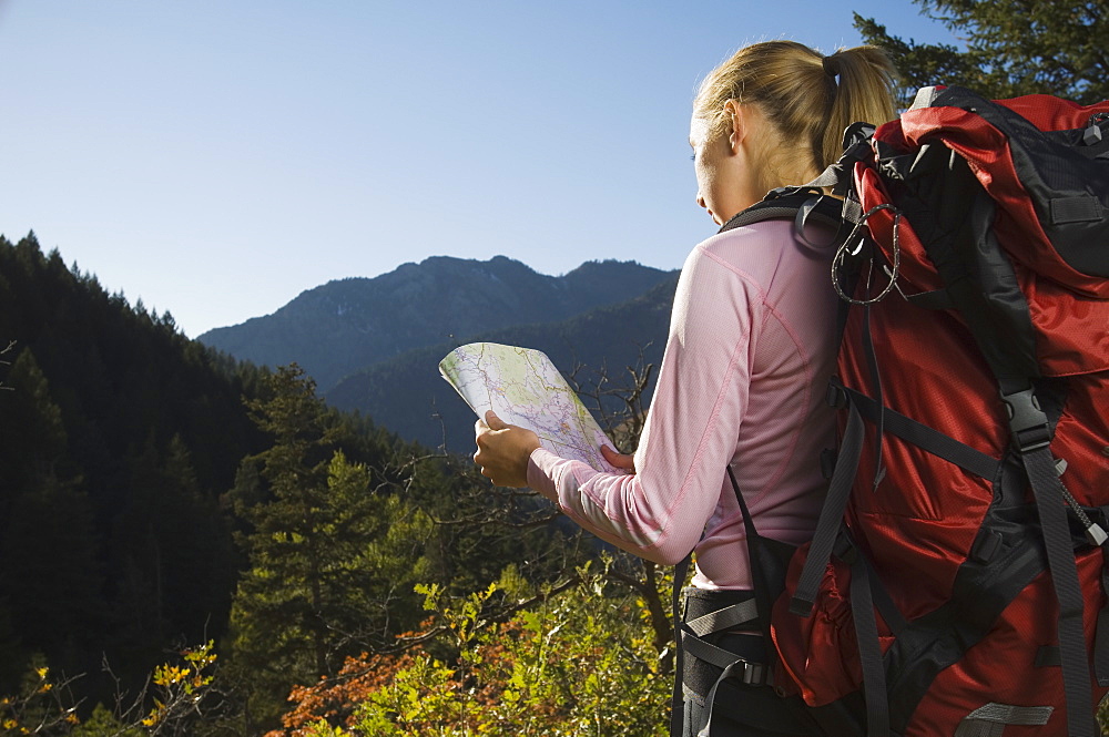 Female hiker looking at map, Utah, United States