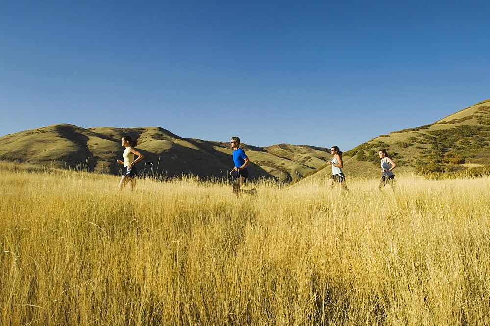 Group of people running in field, Utah, United States