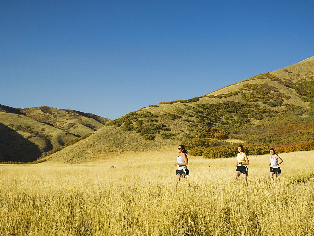 Group of people running in field, Utah, United States