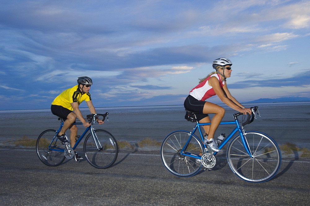 Couple cycling on road, Utah, United States