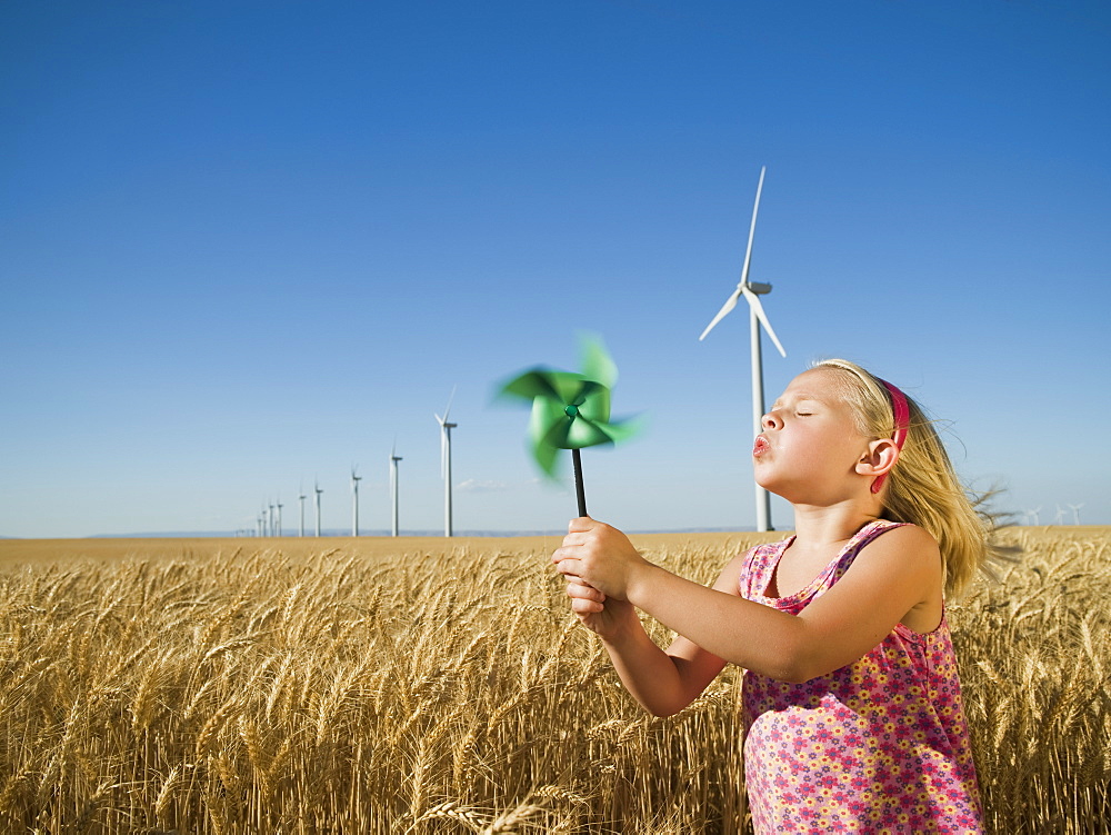 Girl holding pinwheel on wind farm