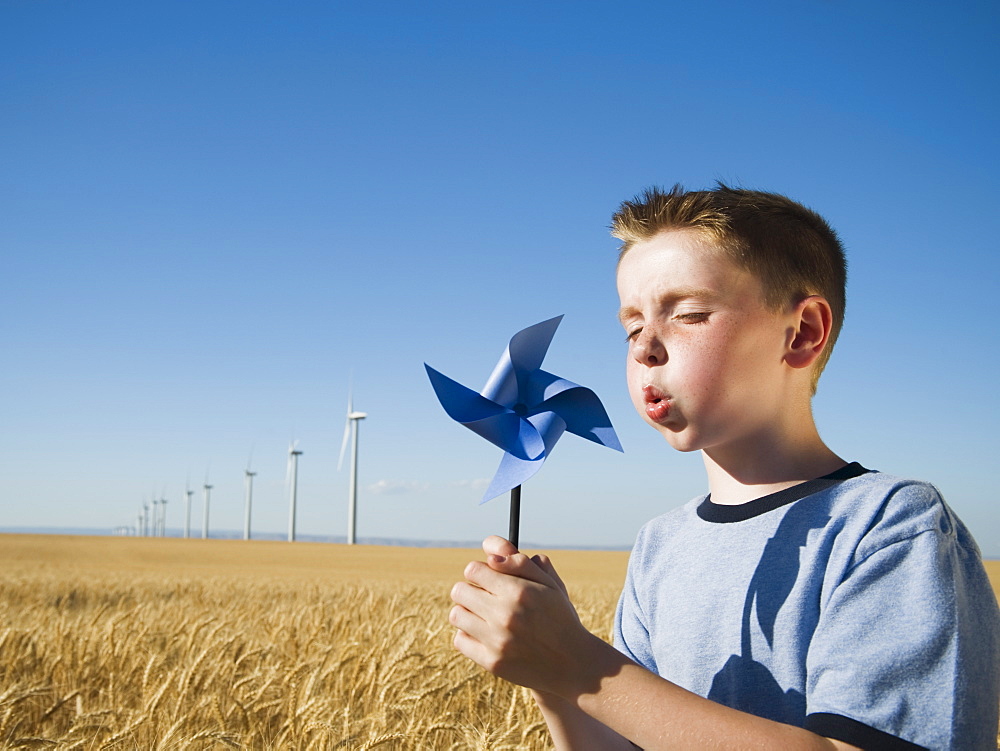 Boy holding pinwheel on wind farm