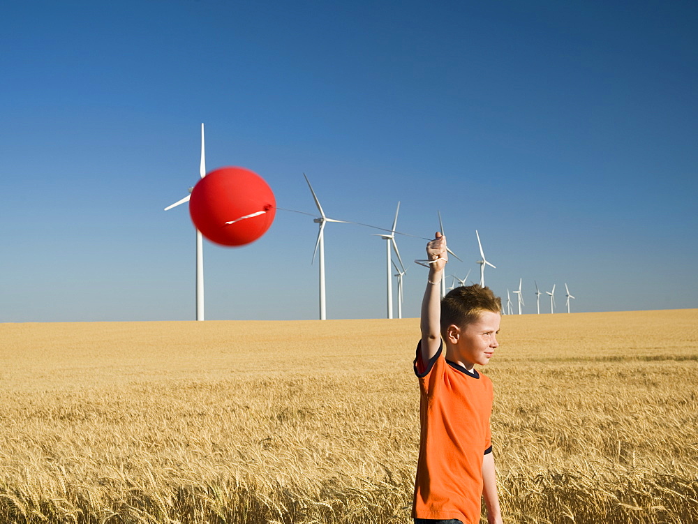 Boy holding balloon on wind farm