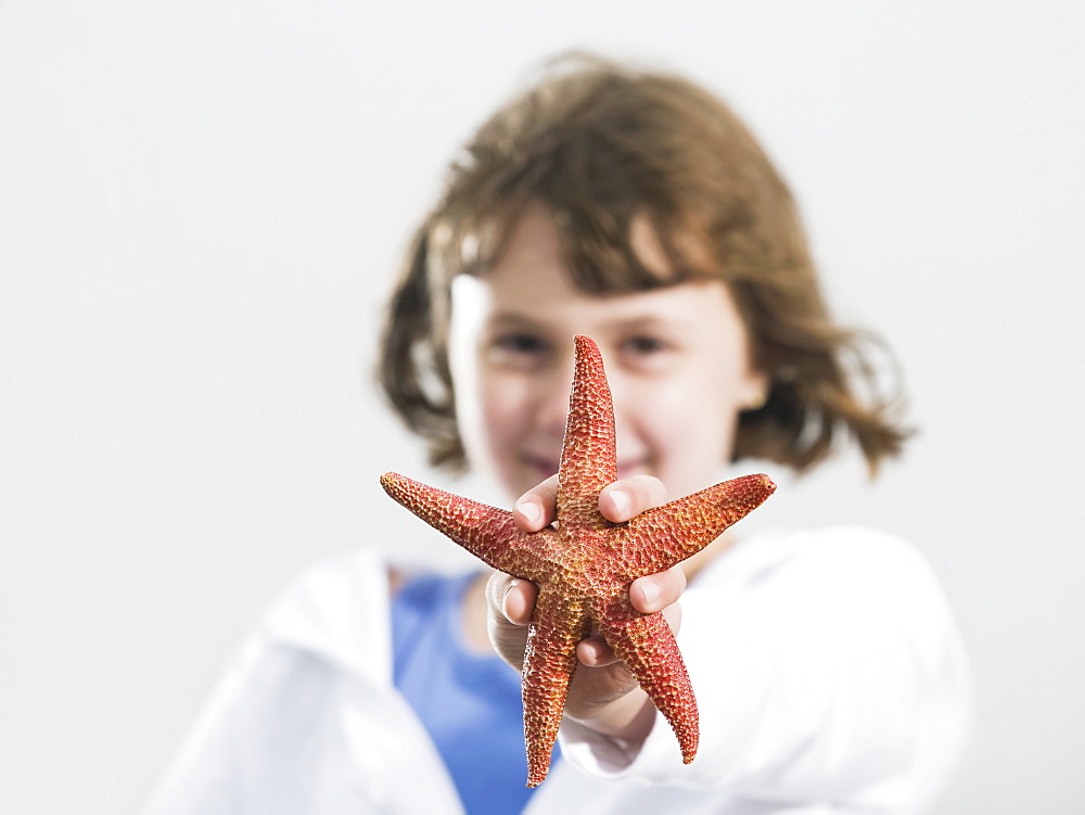 Portrait of girl holding starfish