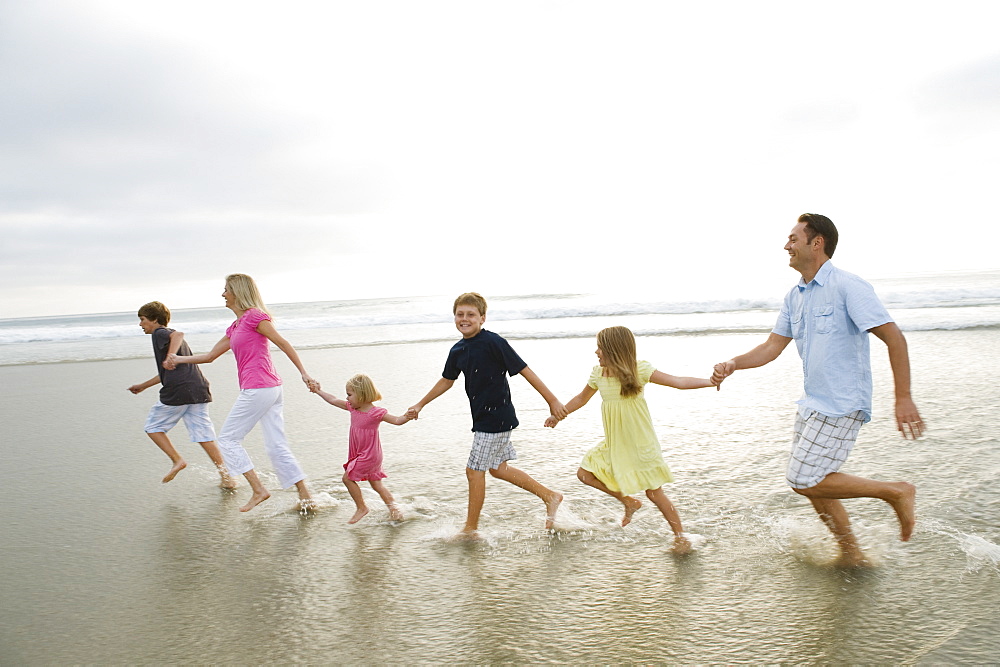 Family holding hands in ocean