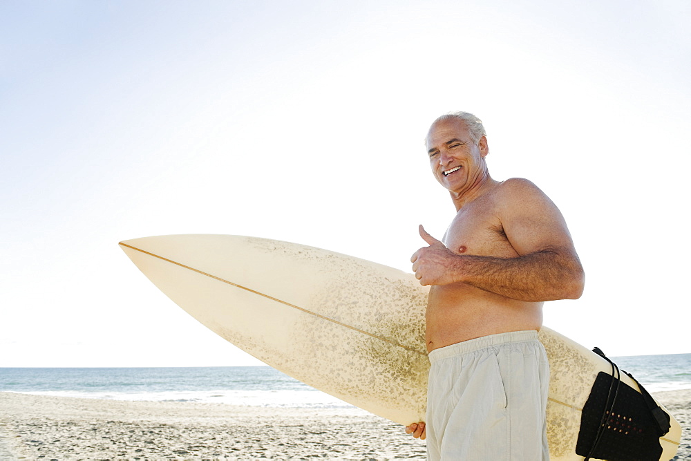 Man holding surfboard on beach