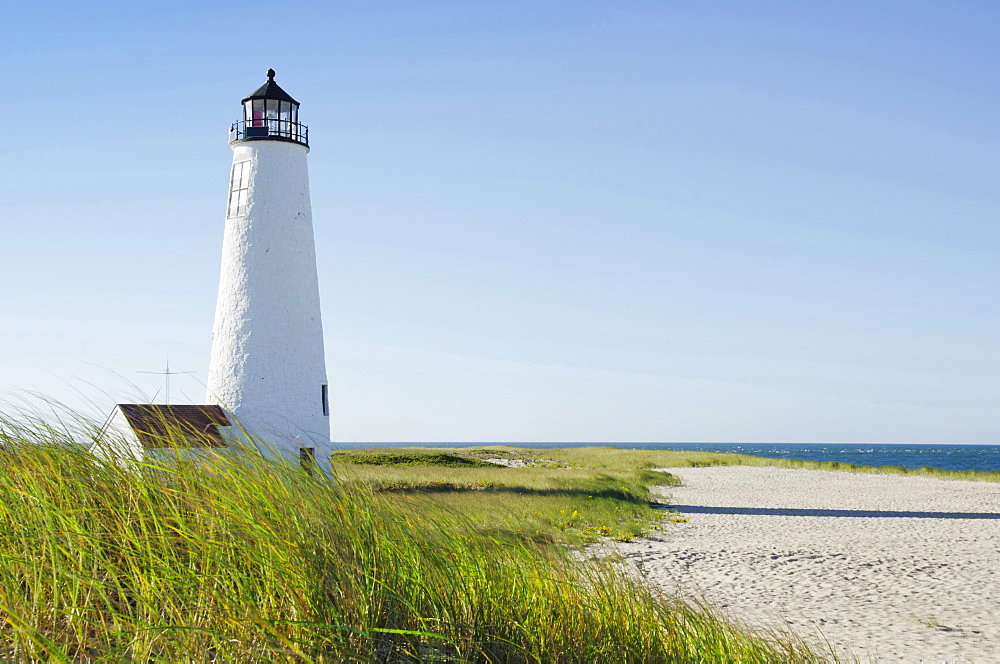 Great Point Lighthouse on overgrown beach against clear sky, Nantucket, Massachusetts, USA