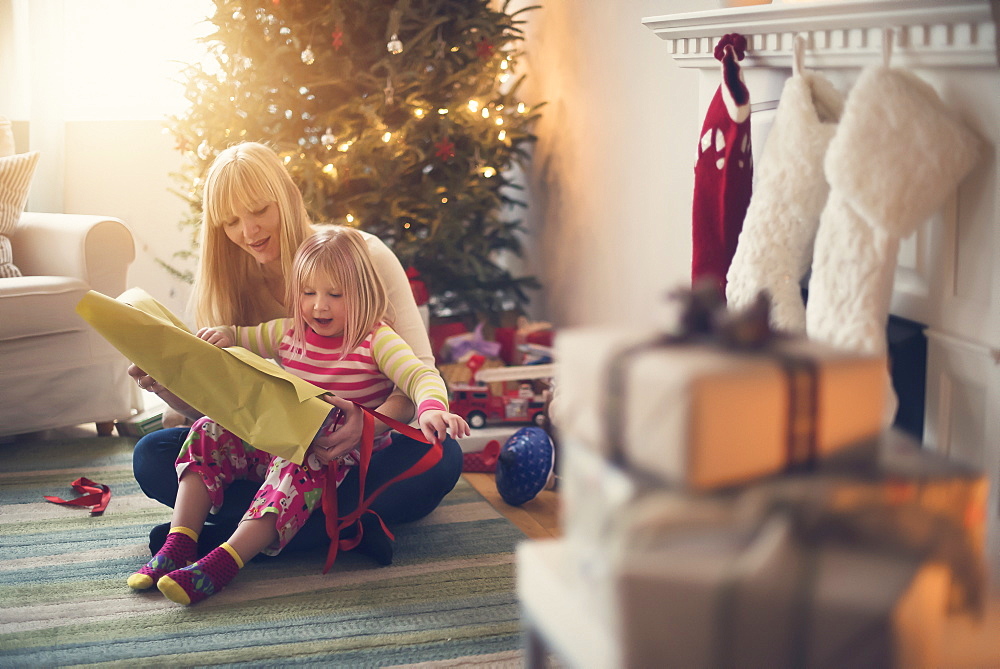 Mother and daughter (4-5) opening christmas presents