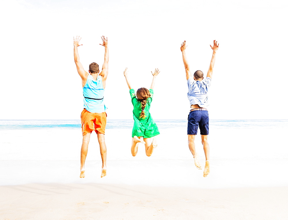Young people jumping on beach, Jupiter, Florida