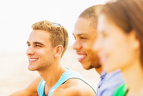 Portrait of young man with defocused view of friends in foreground