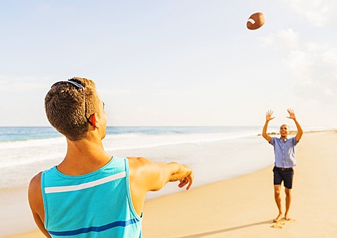 Young men playing football on beach, Jupiter, Florida