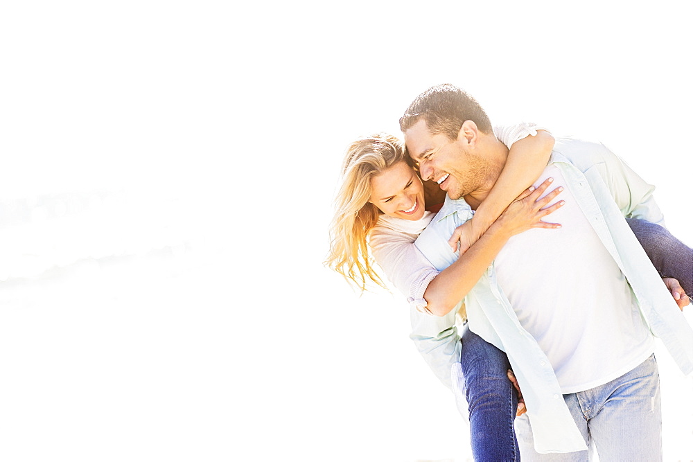 Man giving woman piggyback ride, Jupiter, Florida