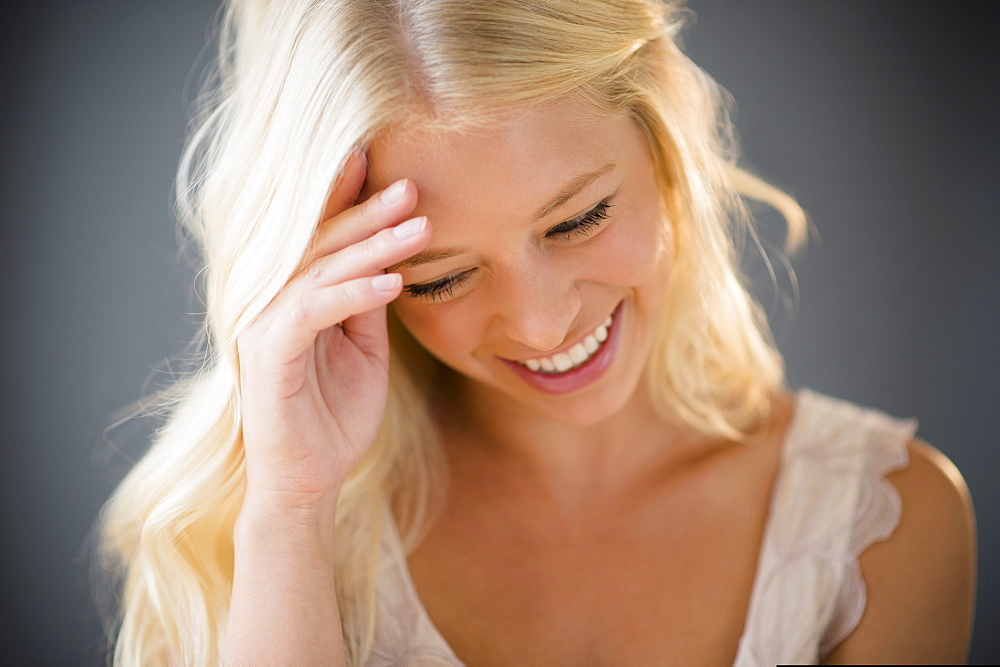 Portrait of young woman braiding hair