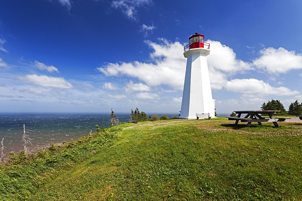 Cape George Lighthouse on green seaside cliff, Nova Scotia, Canada