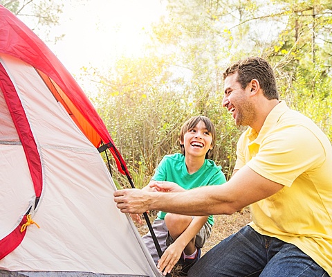 Father and son (12-13) setting up tent, Jupiter, Florida