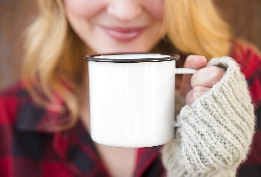 Woman holding metal coffee mug