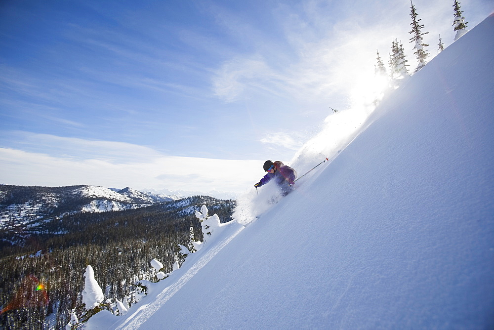 View of young man skiing in snowcapped mountains, Whitefish, Montana, USA