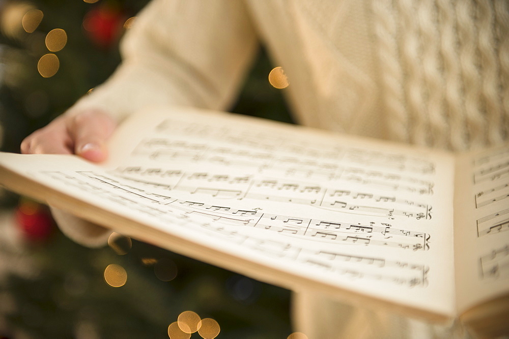 Studio Shot of woman holding sheet music at christmas