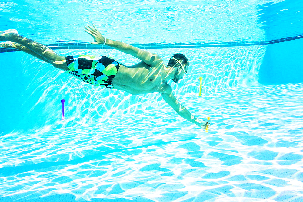 Side-view of young man swimming in pool, Florida,USA