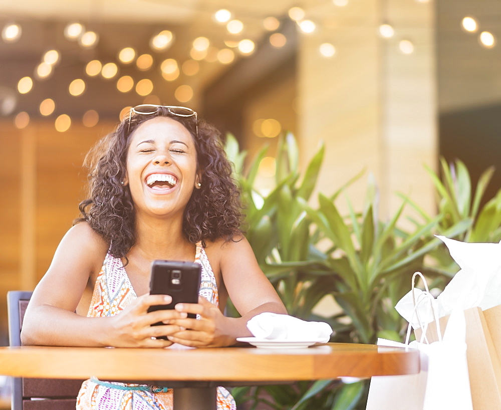 Woman using phone in cafe