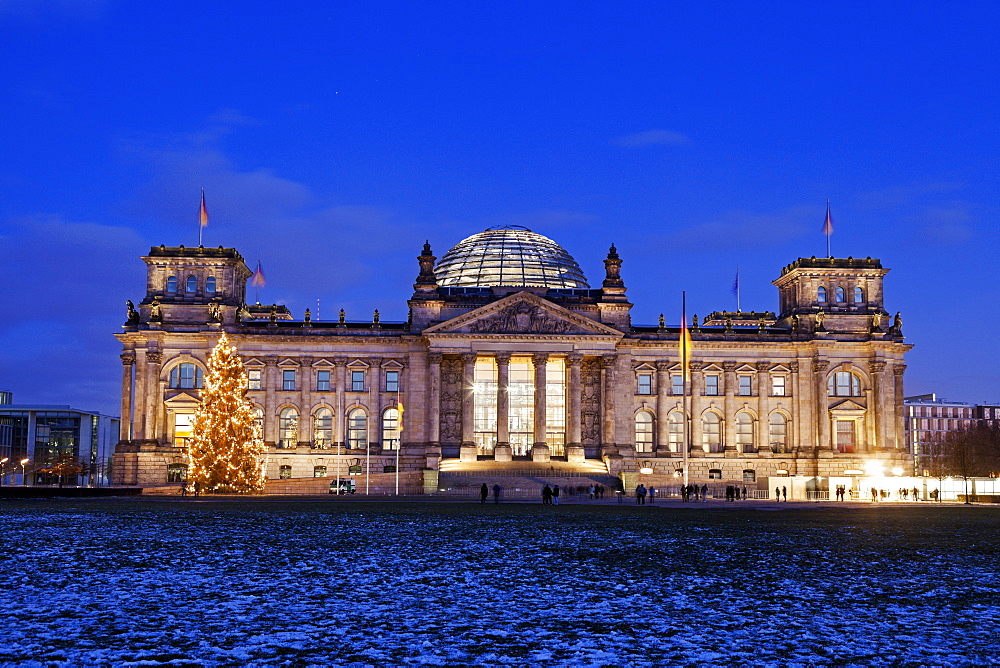 Illuminated Bundestag building and snowy lawn, Germany, Berlin, Reichstag building