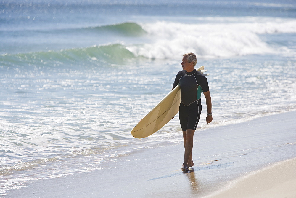 Man carrying surfboard at beach