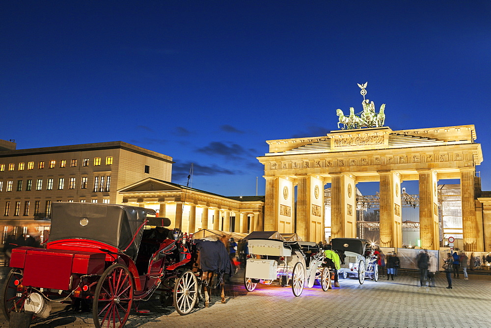 Horse carts in front of illuminated Brandenburg Gate, Germany, Berlin, Brandenburg Gate