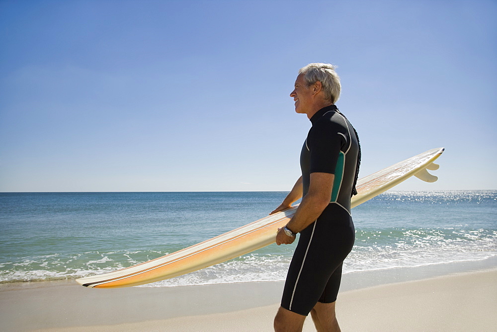 Man holding surfboard at beach